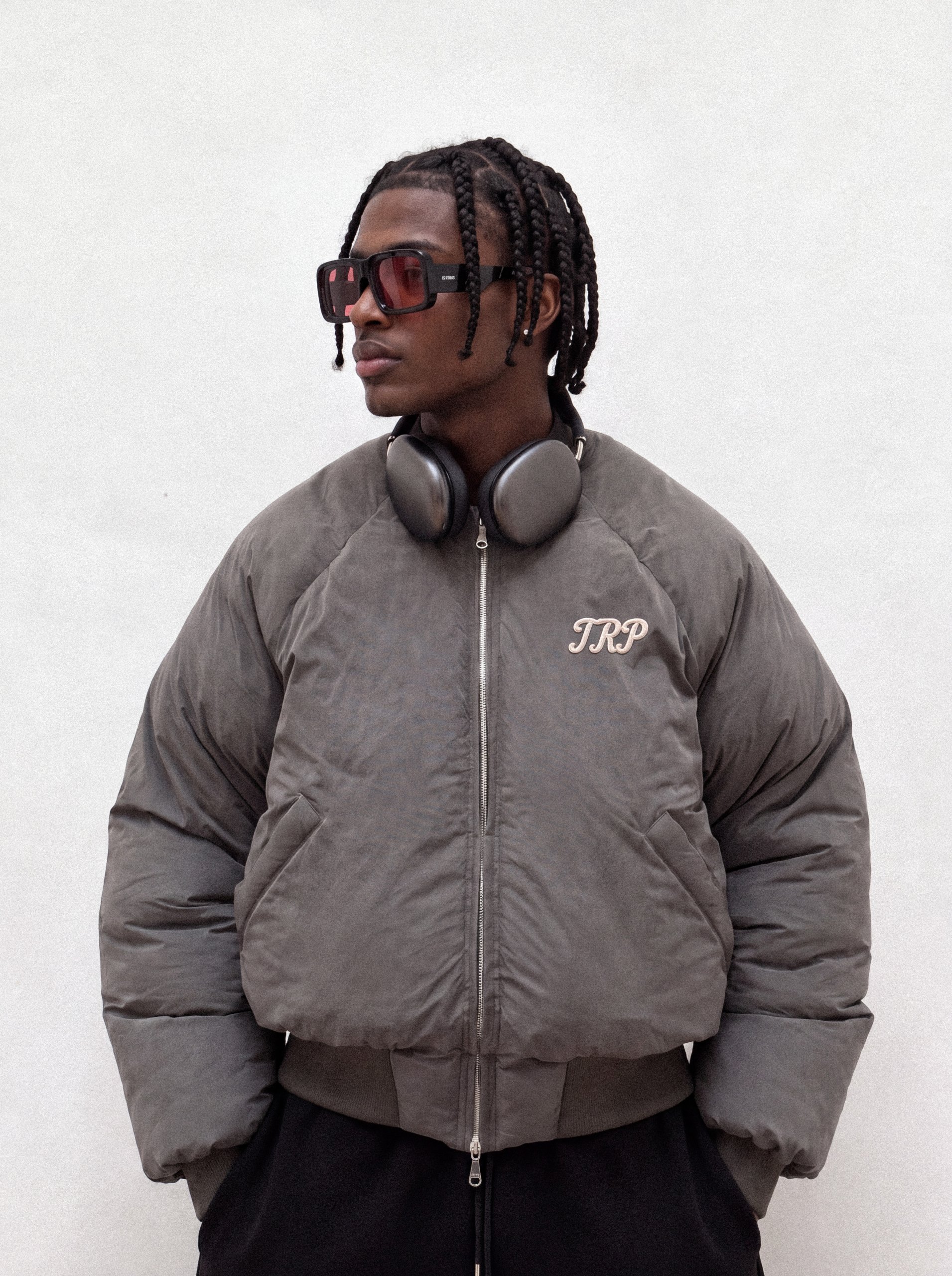 TRP campaign: model wearing a grey TRP jacket, sunglasses and headphones